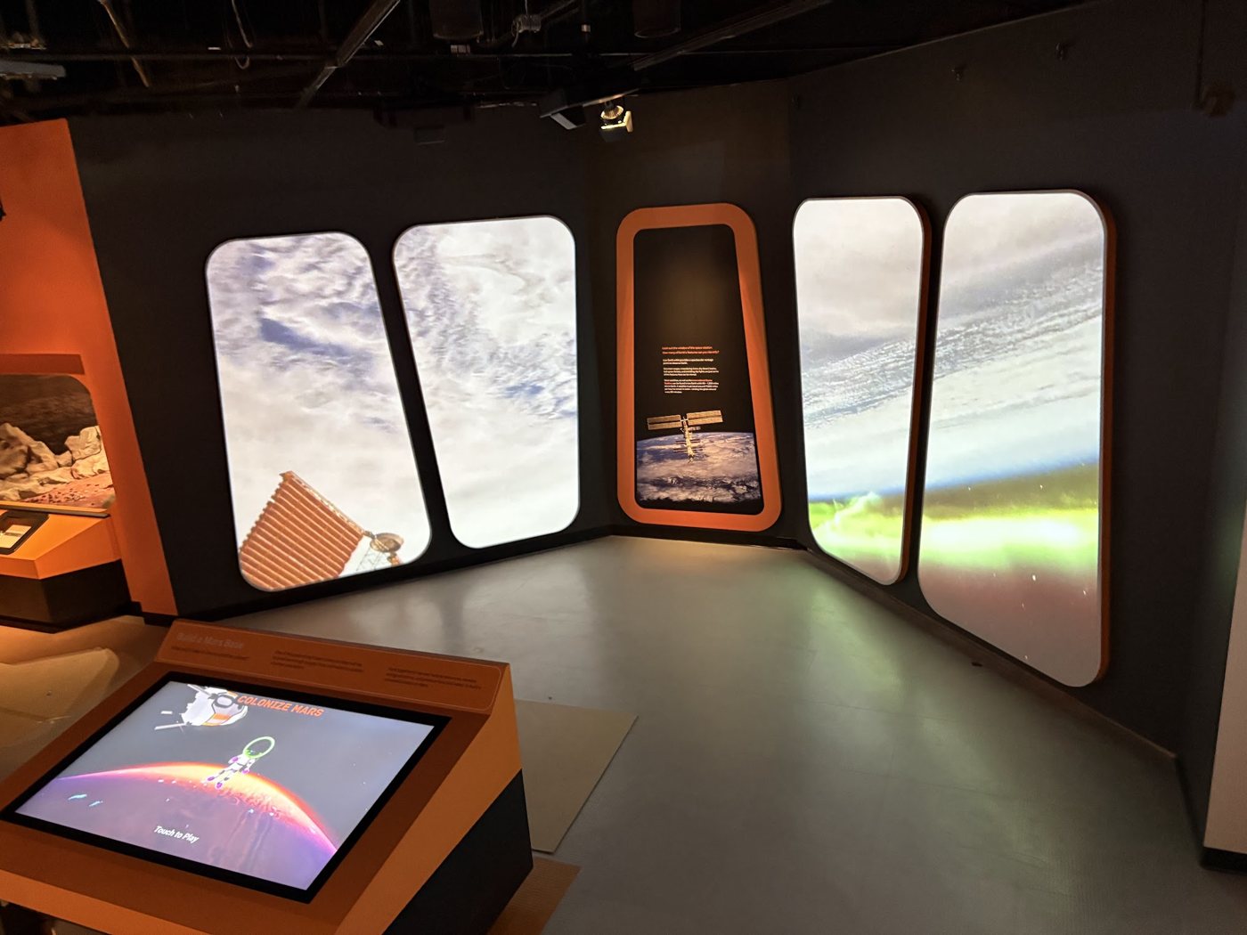 Space exploration exhibit with window-shaped projection screens and a Mars touch table